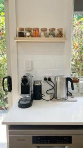 a kitchen counter top with a toaster and a tea kettle at Honey Fig Cottage, Bowral in Bowral