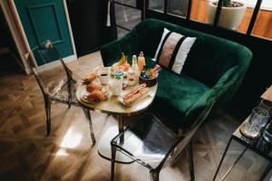 ボルドーにあるLa Belle Endormie B&B French Guest houseの食卓と緑のソファ