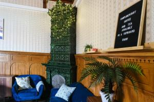 a living room with a blue couch and a green column at Hostel Diana Park in Helsinki