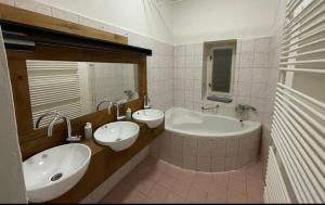a bathroom with two sinks and a bath tub at Red&Black Apartment City centr, Na Hradbách 118 in Ostrava