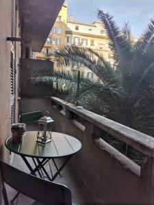 einen Tisch und Stühle auf einem Balkon mit einer Palme in der Unterkunft Hotel Principe Eugenio in Rom