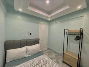 ein Schlafzimmer mit einem Bett und einer weißen Wand in der Unterkunft The PAD Staycation 2BR Condo with PS4, Netflix, WIFI in Manila