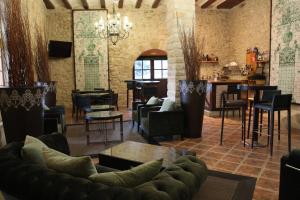 sala de estar con sofá, sillas y bar en Hotel Palacio Dos Olivos, en Galdeano