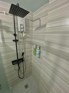 Das Bad ist mit einer Dusche mit Duschkopf und einer Dusche ausgestattet. in der Unterkunft The PAD Staycation 2BR Condo with PS4, Netflix, WIFI in Manila + 5 Fotos
