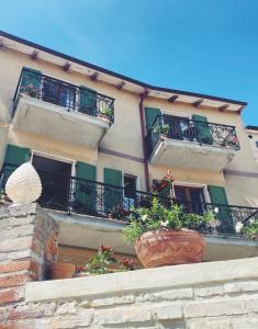 a building with balconies and potted plants on a wall at Casa Agello B&B in Ripatransone
