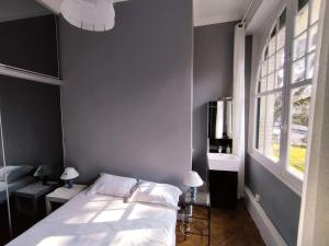 een slaapkamer met een wit bed en een raam bij Le Moulleau Appartement 2 chambres - plage à 50m in La Teste-de-Buch