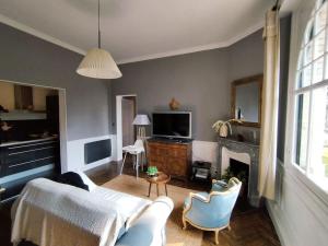 een woonkamer met een bank en stoelen en een tv bij Le Moulleau Appartement 2 chambres - plage à 50m in La Teste-de-Buch