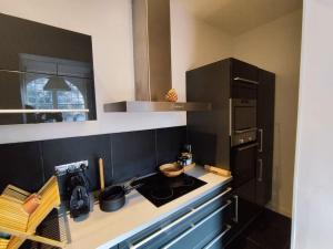 a small kitchen with a stove and a refrigerator at Le Moulleau Appartement 2 chambres - plage à 50m in La Teste-de-Buch