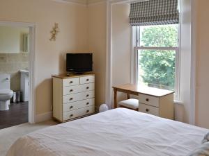 a bedroom with a bed and a desk and a window at Lavender in Stokeinteignhead