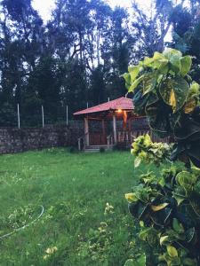 a gazebo in a yard with green grass at Little bungalow Holiday Home, Coorg in Somvārpet