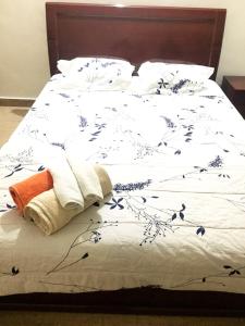 a white bed with blue flowers on it at Little bungalow Holiday Home, Coorg in Somvārpet