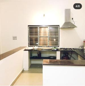 a kitchen with a sink and a stove top oven at Little bungalow Holiday Home, Coorg in Somvārpet