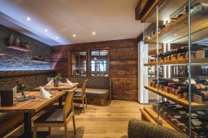 a restaurant with wooden tables and chairs and a bar at Naturhotel Lärchenhof in Mittelberg