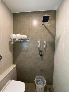 een badkamer met een toilet en een douche met een zonnepaneel bij Le Shiv Executive Suite in Theni