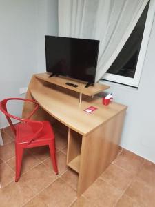 a desk with a television and a red chair at Heraklion modern studio 40 sq.m. near town center. in Heraklio