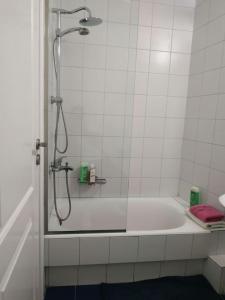 a white bathroom with a shower and a tub at Heraklion modern studio 40 sq.m. near town center. in Heraklio