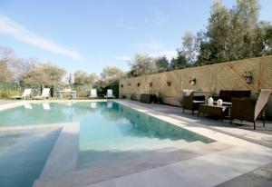 una piscina en un patio con sillas y mesa en Casa Regno, en Ayiá