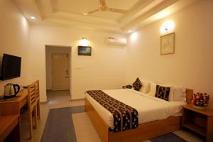 a hotel room with a bed and a television at Iceberg Hill View Resort Munnar in Munnar