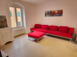 a living room with a red couch and a window at Casa Anelita in La Spezia