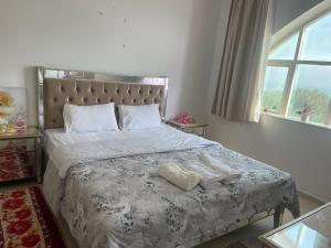 a bedroom with a bed with two towels on it at Discover Khorfkan in Khor Fakkan