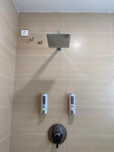 een badkamer met twee zeepdispensers aan de muur bij Le Shiv Executive Suite in Theni
