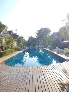 a large swimming pool with a wooden deck in a house at House in Ban Phe, Thailand in Rayong