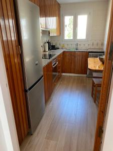 a kitchen with a stainless steel refrigerator and a wooden floor at VORAMAR Apartamento in Cadaqués