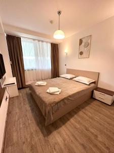 a bedroom with a large bed with two towels on it at Forest View Silver M B34 Poiana Brasov in Poiana Brasov