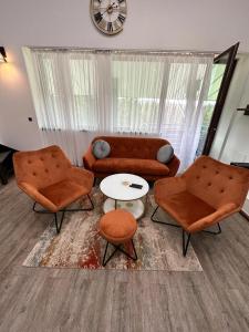 a living room with two chairs and a couch and a table at Forest View Silver M B34 Poiana Brasov in Poiana Brasov