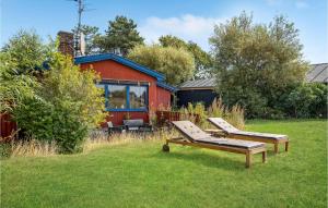a house with two lounge chairs in the grass at Beautiful Home In Slagelse With House Sea View in Slagelse
