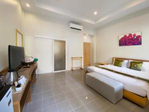 a bedroom with a large bed and a television at Simply Resort in Kata Beach