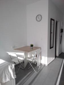 a table and chairs in a white room with a clock at Casa Carmelina in Torrevieja +8 photos