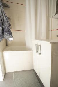 a white bathroom with a shower and a tub at Casa Carmelina in Torrevieja