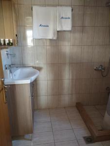 a bathroom with a sink and a shower with towels at Miranda Studios in Paliouri