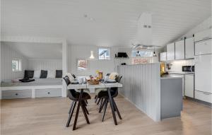 Una cocina con una mesa y sillas y una cama. en Three-Bedroom Holiday Home In Haderslev, en Sønderballe