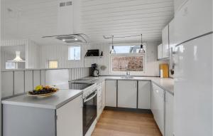 Una cocina blanca con un frutero en la encimera. en Three-Bedroom Holiday Home In Haderslev, en Sønderballe