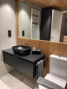 bagno con lavandino nero e specchio di Apartaran 407 con terraza a Betrén