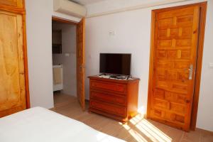 Dormitorio con cama y tocador con TV en Lovely house a few steps to the beach with sea view en Vélez-Málaga