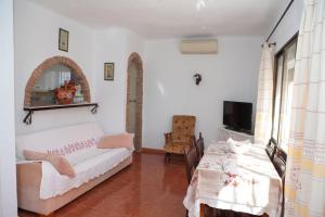 um quarto com duas mesas e uma cama e uma televisão em Lovely house a few steps to the beach with sea view em Vélez-Málaga