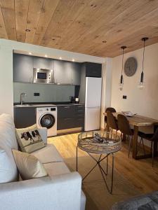 a living room with a white couch and a table at Apartaran 407 con terraza in Betrén +16 photos