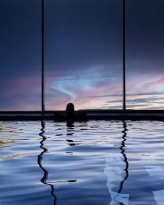 a person is sitting in a pool of water at Albergo Moderno & Spa in Fuipiano Valle Imagna