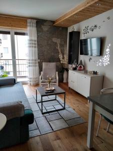 ein Wohnzimmer mit einem Sofa und einem Tisch in der Unterkunft Condominio Baradello in Aprica