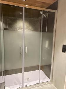 box doccia con porte in vetro in una stanza di Apartaran 407 con terraza a Betrén