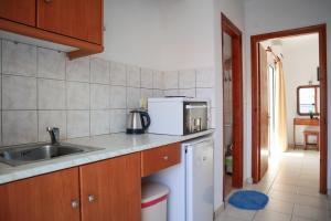 a kitchen with a sink and a microwave at Spyridoula in Lourdhata