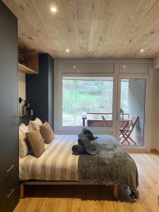 una camera da letto con un grande letto con una grande finestra di Apartaran 407 con terraza a Betrén