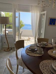 a dining room with a table with a view of the ocean at Villa Bounatsa with access to semi-private beach in Kanapitsa