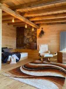 a room with a bed and a chair and a rug at Albergo Moderno & Spa in Fuipiano Valle Imagna