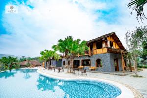 a villa with a swimming pool and a house at Mường Lò Retreat Nghia Lo in Yên Bái