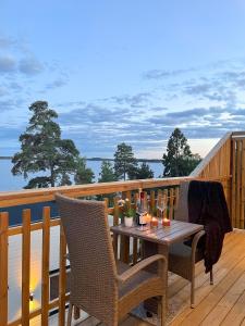 a wooden deck with a table and chairs on a balcony at New lakehouse - amazing sea view and private pier! in Stockholm