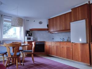 uma cozinha com armários de madeira e uma mesa com cadeiras em Ferienwohnung Elisa em Innsbruck